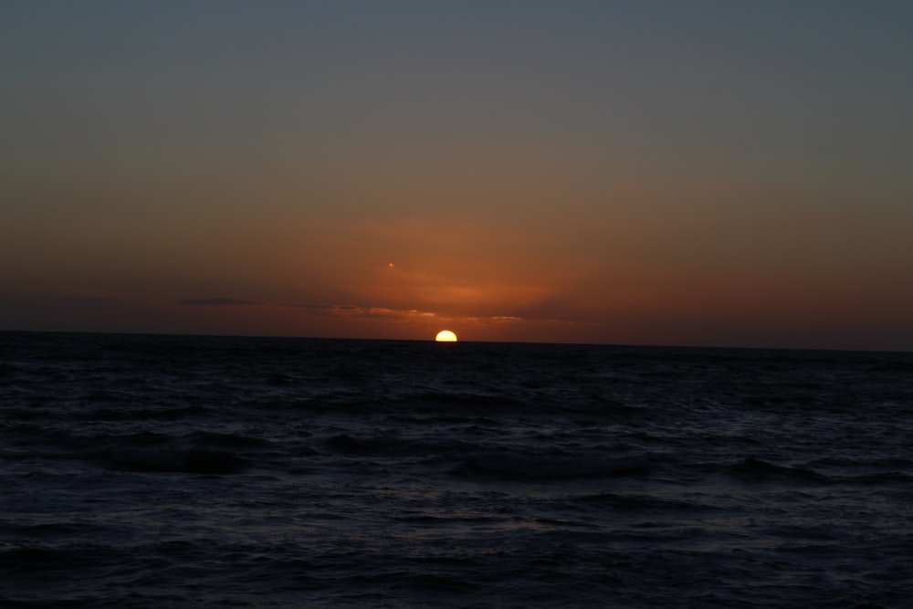Ozean mit Sonnenuntergang im Hintergrund
