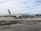 A passenger airplane with the American Airlines logo is positioned on an airport taxiway, featuring overcast skies and various airport markings on the ground.
