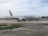 A passenger airplane with the American Airlines logo is positioned on an airport taxiway, featuring overcast skies and various airport markings on the ground.