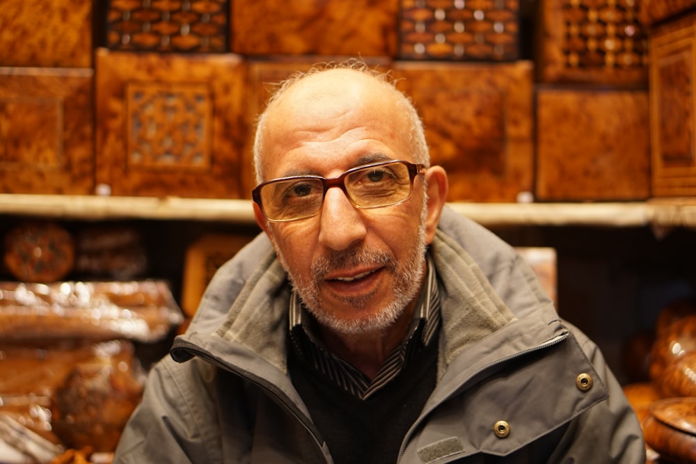 man in hoodie sitting near books