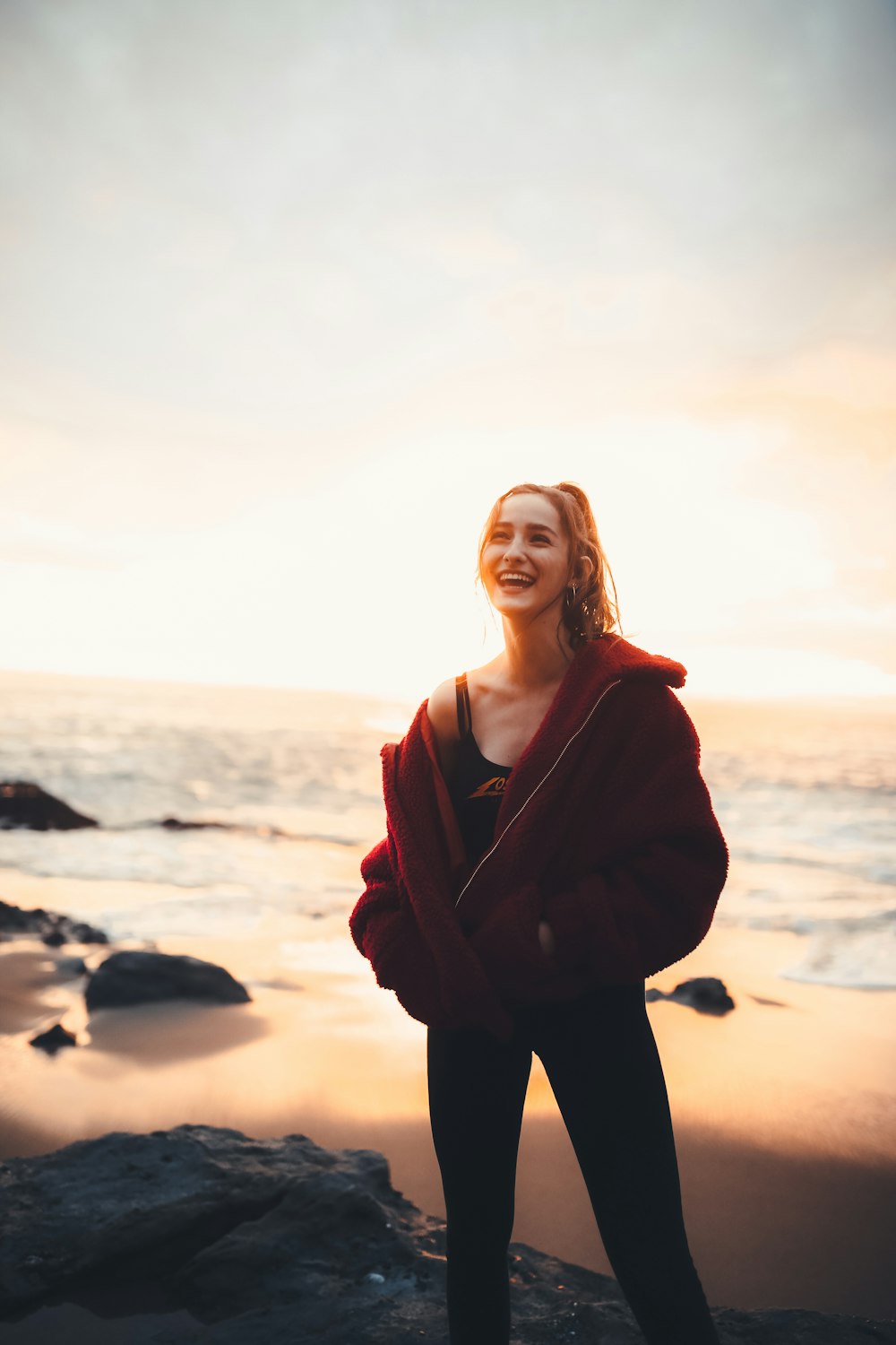 smiling woman standing beside sea