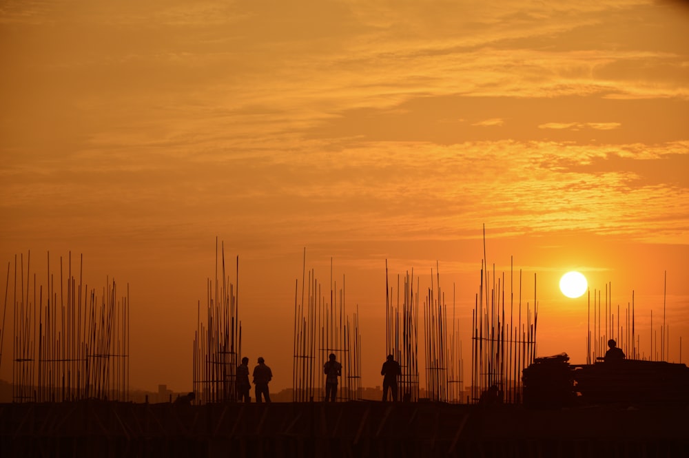 silhouette of people standing near building frame