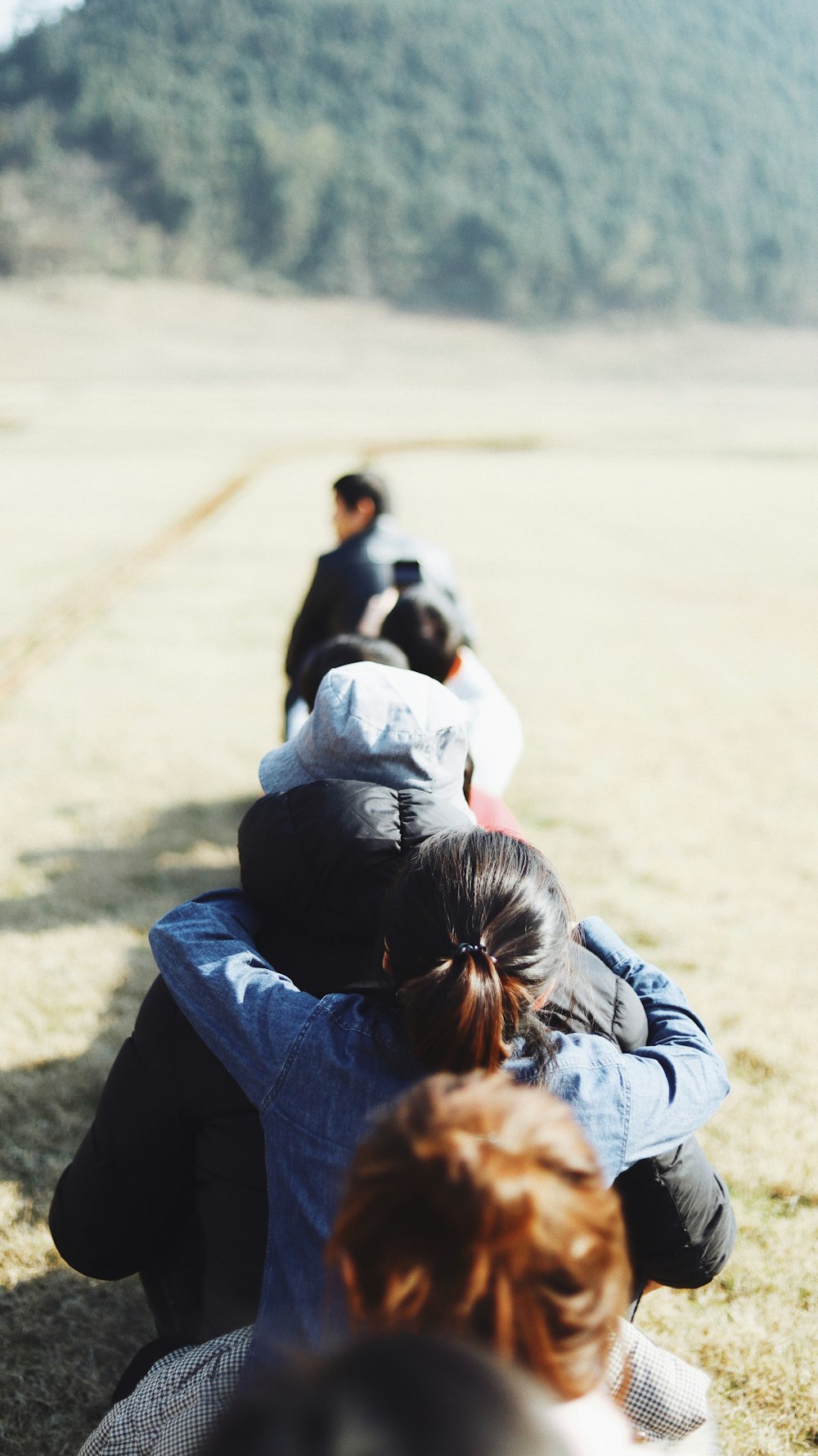 shallow focus photo of people walking near trees