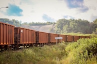 Rail freight cars carrying bulk rice through the scenic landscapes of Pakistan.