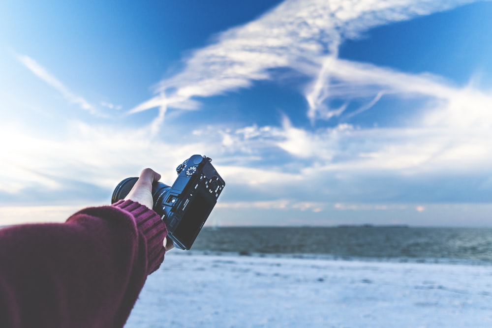 una persona tomando una foto del cielo con un teléfono celular