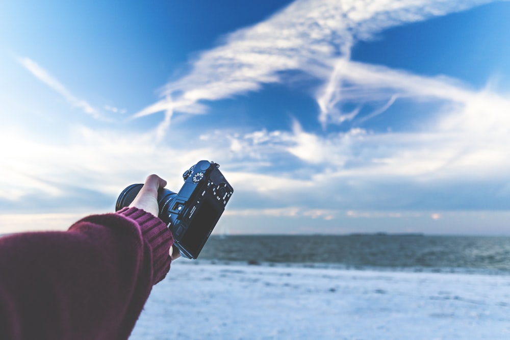 a person taking a picture of the sky with a cell phone