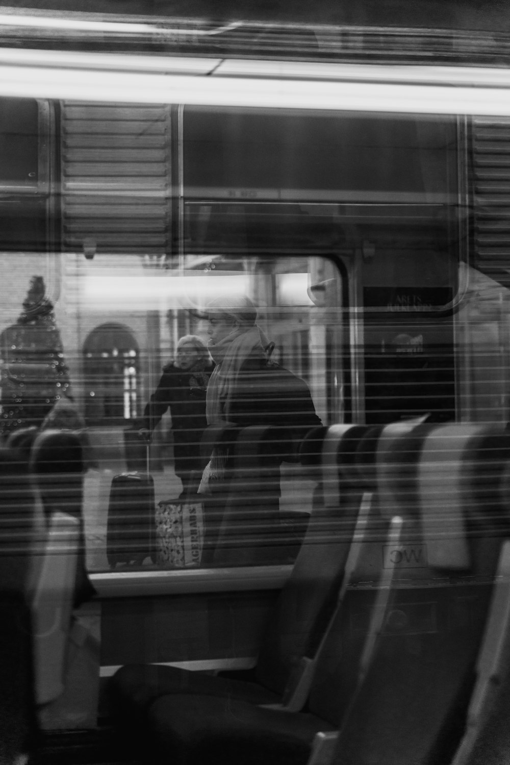 a black and white photo of people sitting on a train