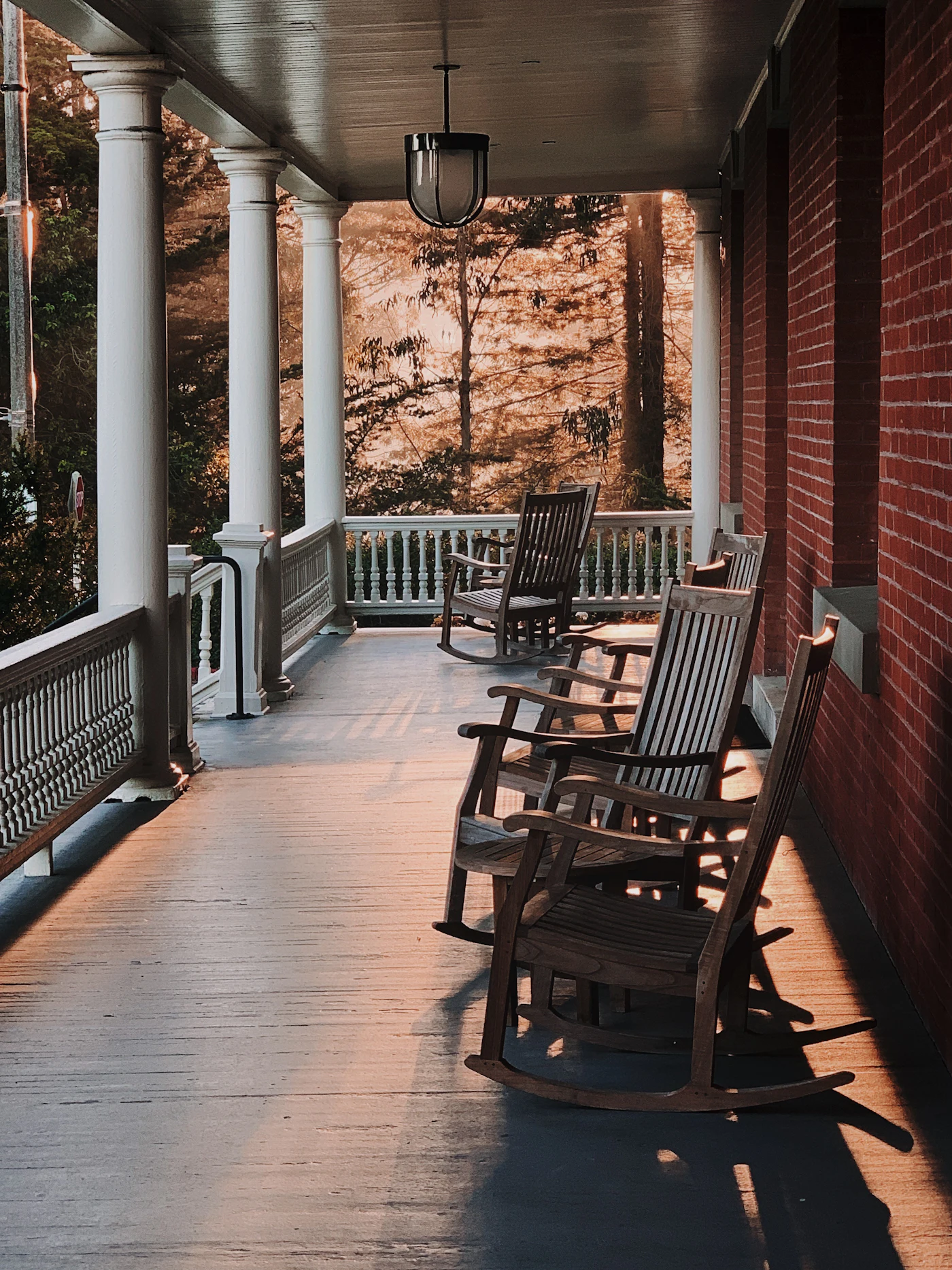 A peaceful covered porch with comfortable rocking chairs in warm afternoon light