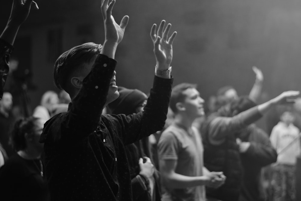 people gathering and raising their hands