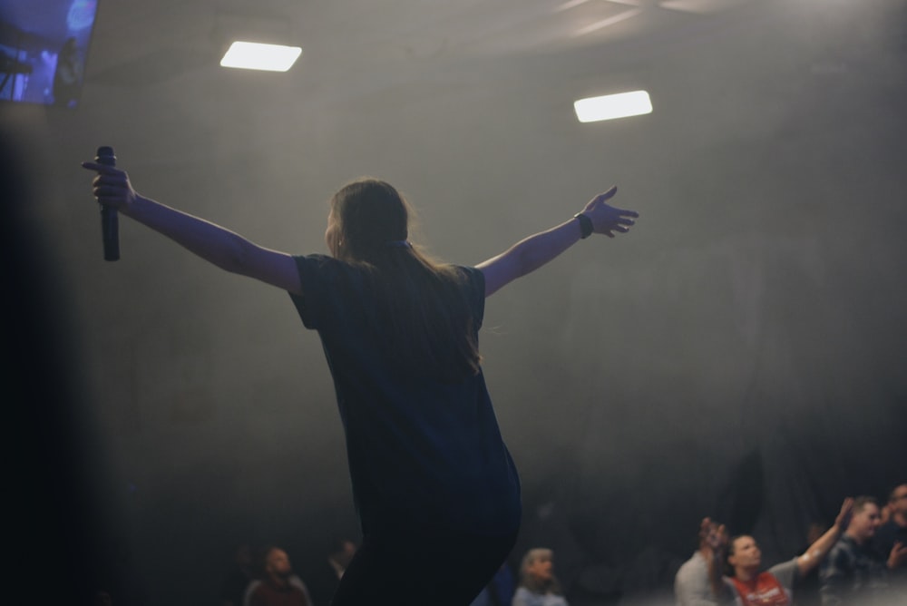 person in black shirt performing on stage in front of people