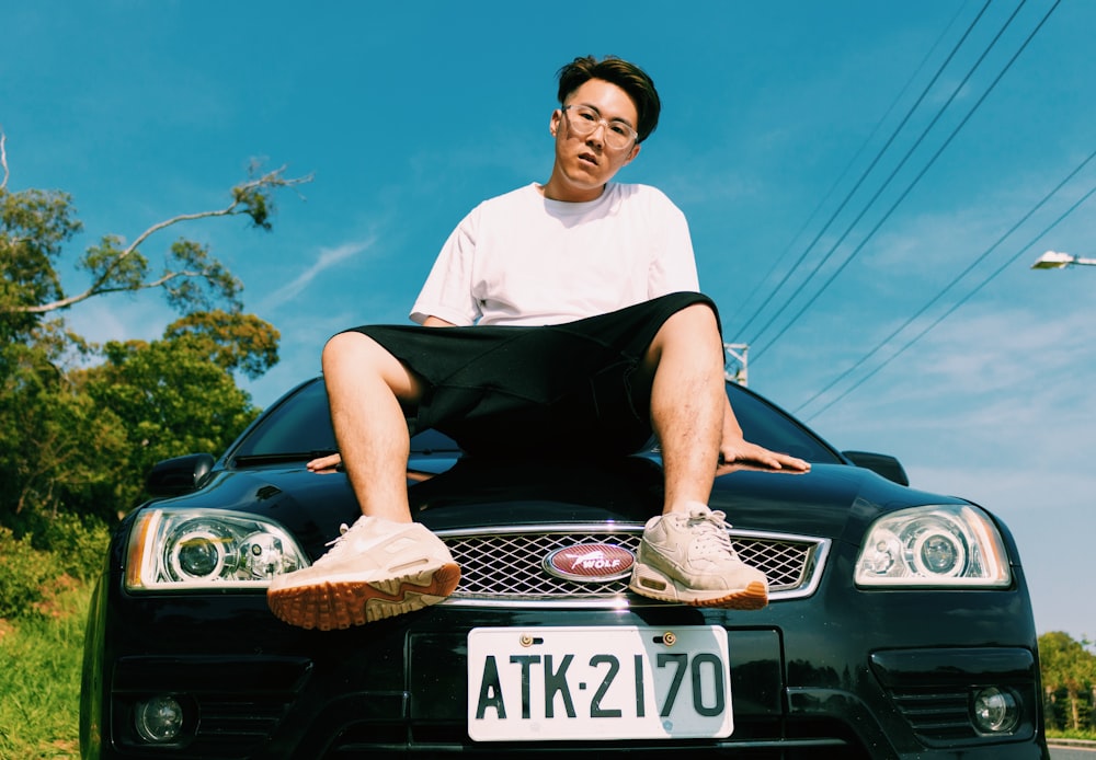 man in white tee shirt sitting on Ford vehicle