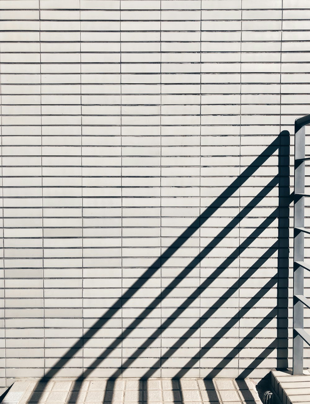 a person sitting on a bench next to a wall