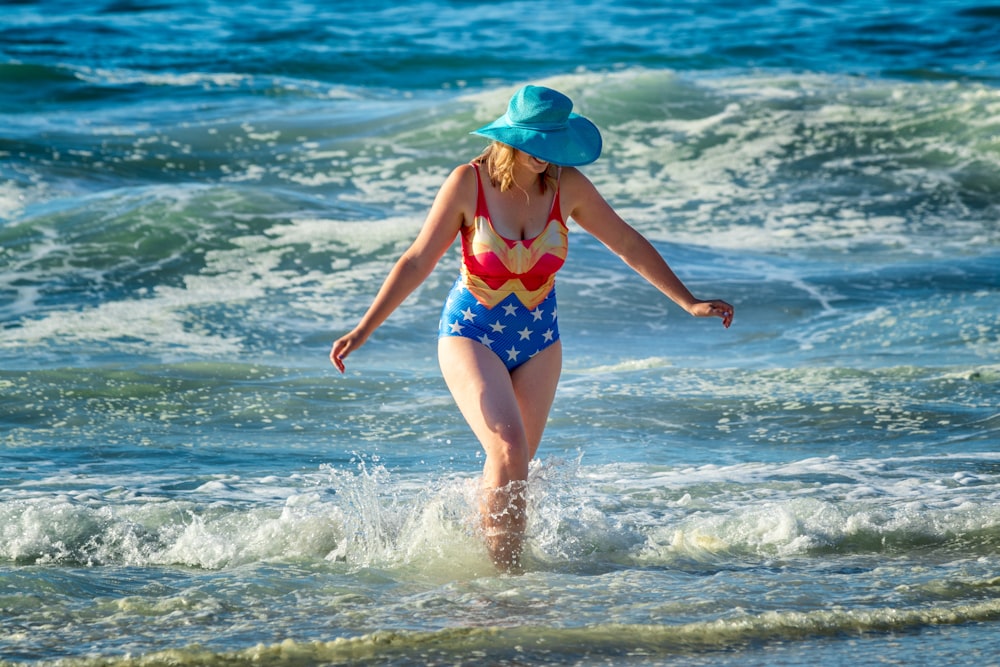 femme en bikini wonder-woman marche sur les vagues de la mer