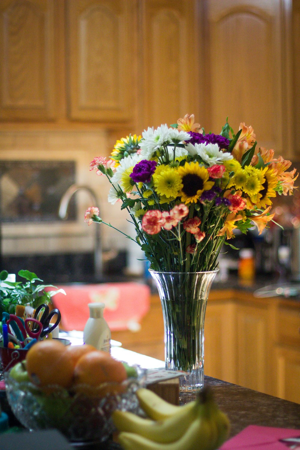 assorted-color petaled flowers on clear glass vase