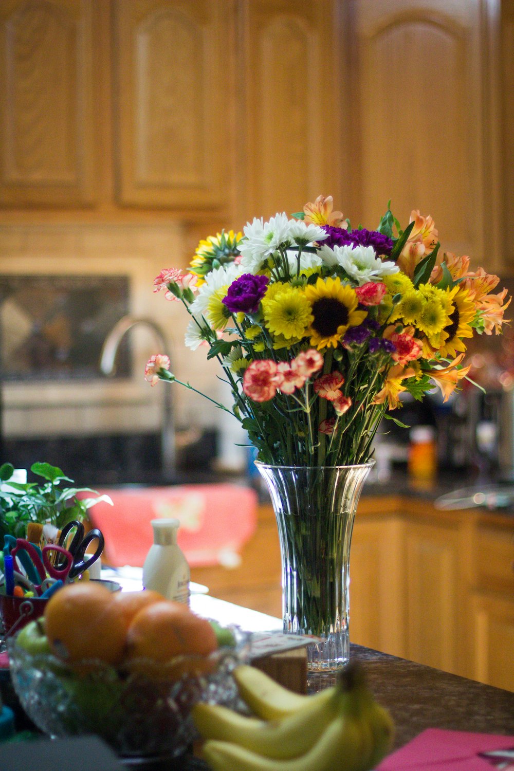 fiori a petali di colori assortiti su vaso di vetro trasparente