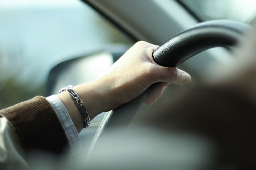 person holding steering wheel