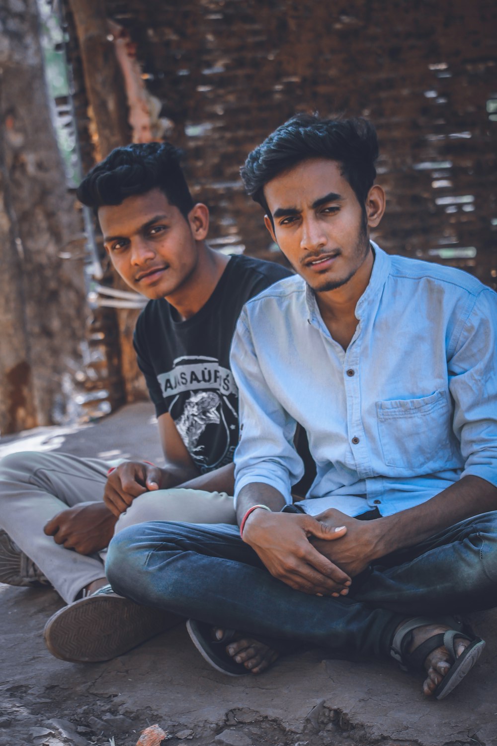 two men sitting near brown wall