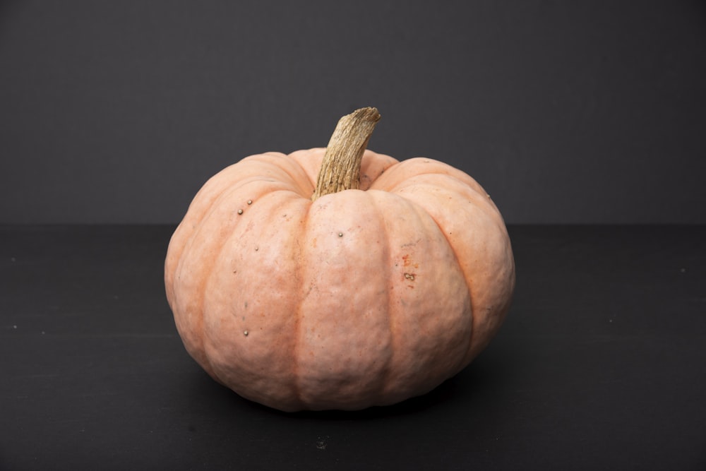 whole orange pumpkin on black surface