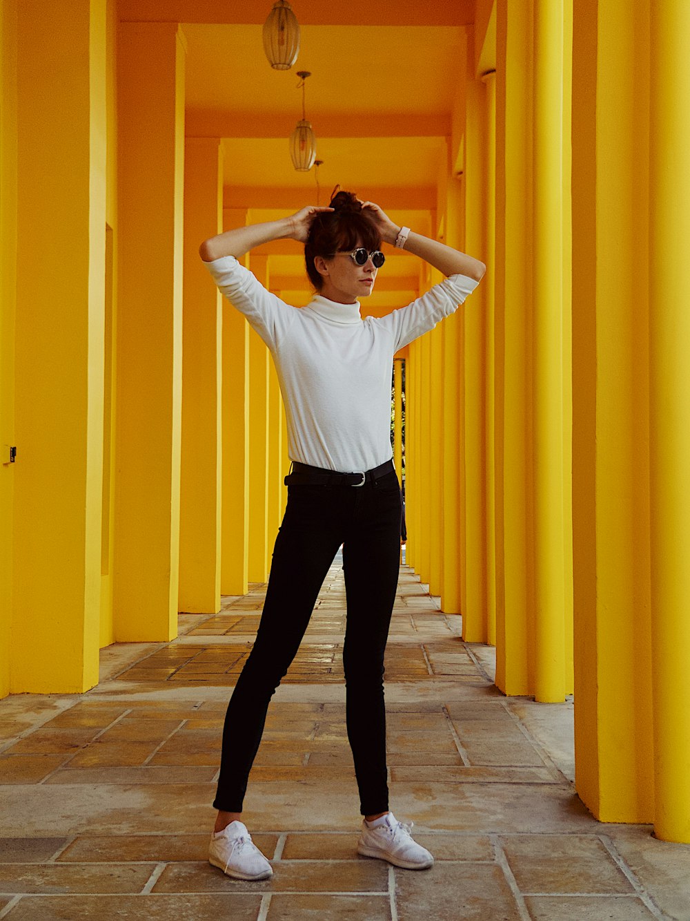 standing woman between posts holding her hair