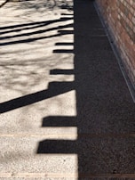 Abstract shadows cast on a concrete wall, creating geometric patterns in black and white.