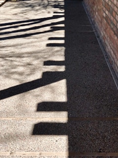 Abstract shadows cast on a concrete wall, creating geometric patterns in black and white.