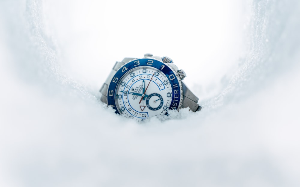round silver-colored chronograph watch on snow