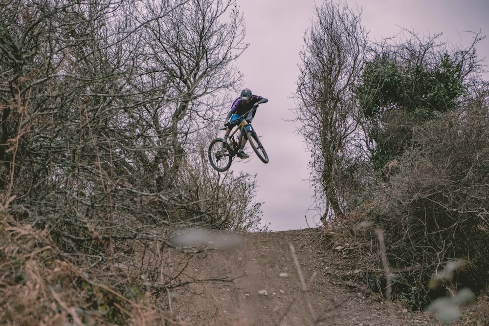 time-lapse photography of man doing bike trick on rough road