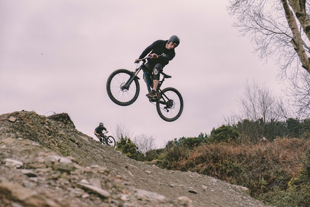 man riding mountain bike by slope during daytime