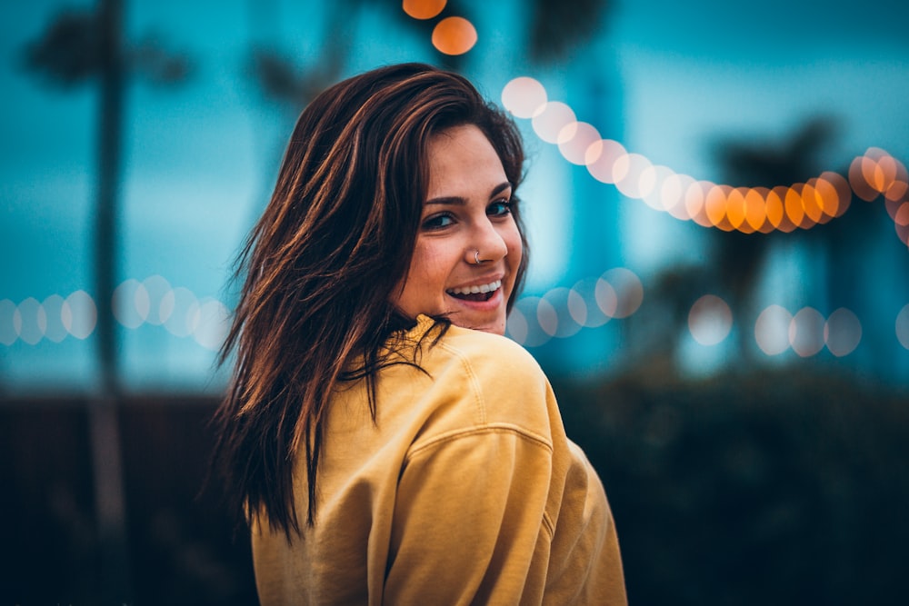 bokeh portrait photography of woman wearing yellow sweatshirt