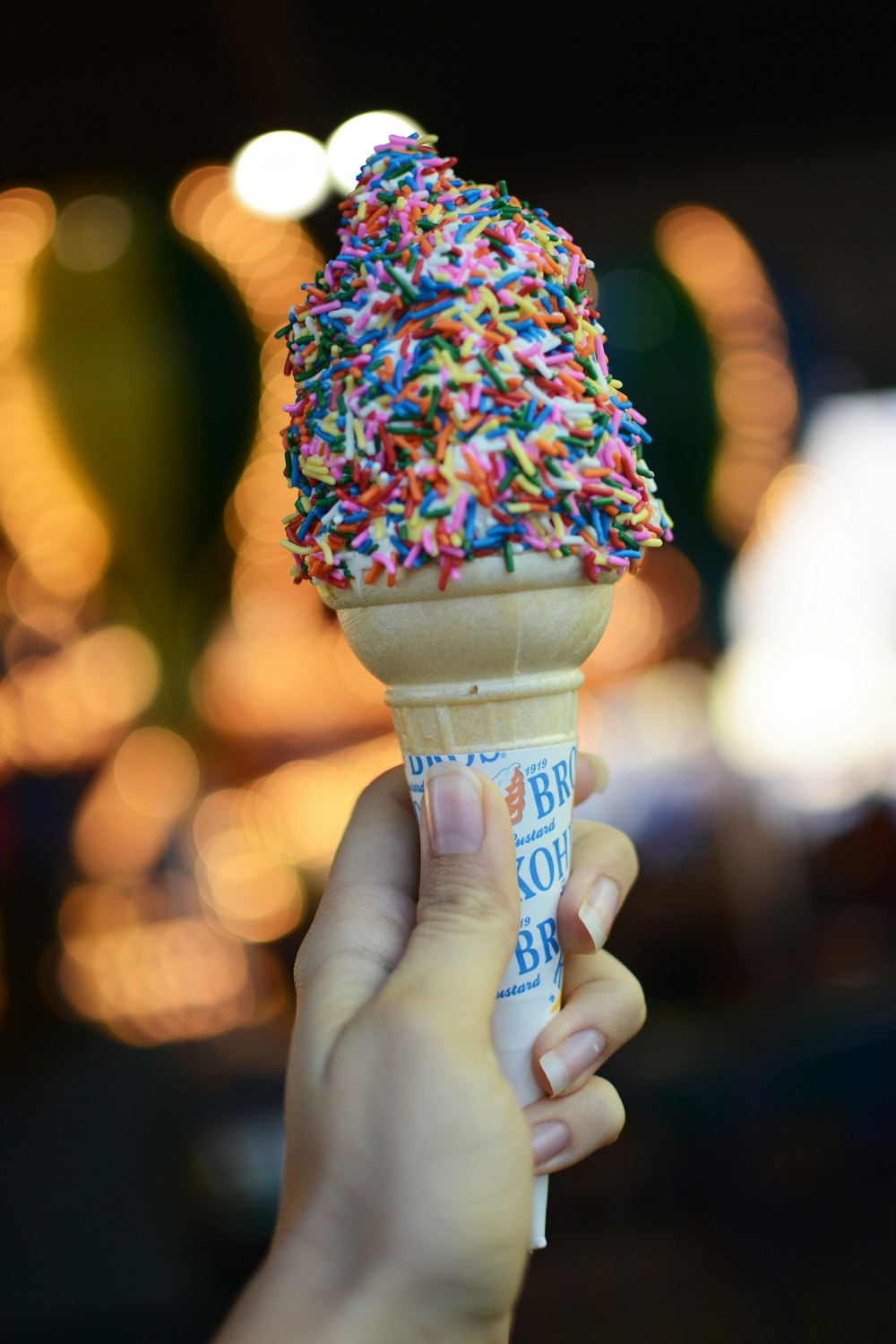person holding cone with sprinkles