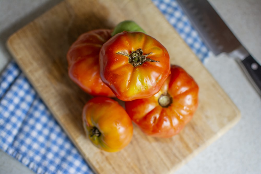 orange tomatoes on brown chopping board