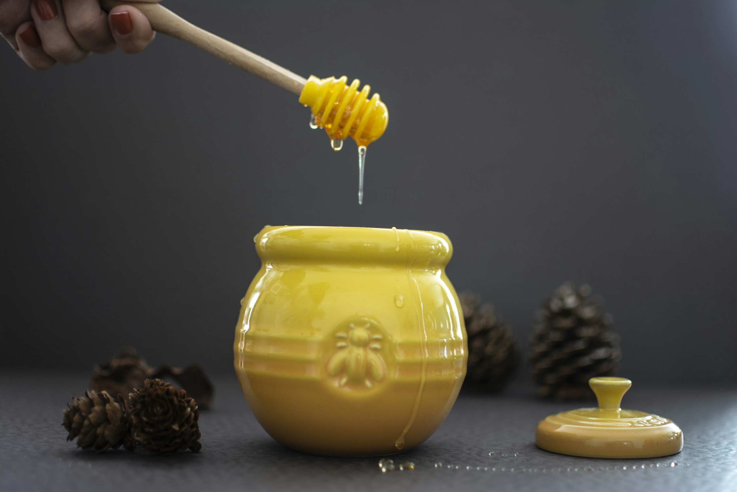 opened yellow ceramic jar beside pine cones