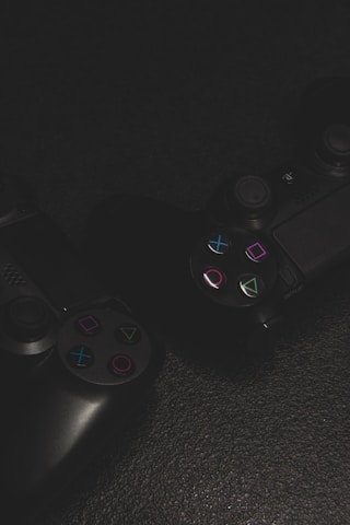 Close-up of colorful game controllers on a dark surface.