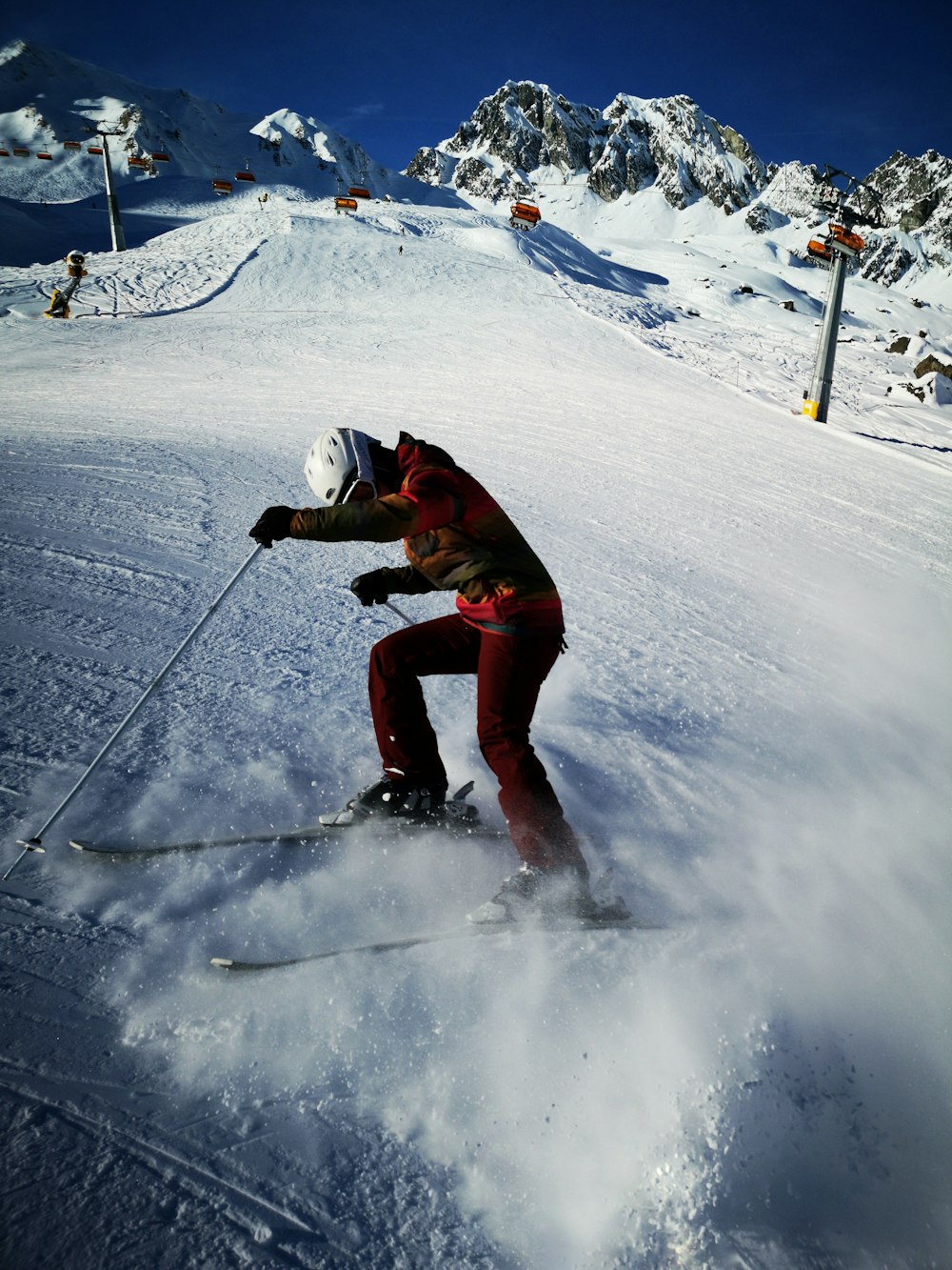 person in full suit with ski blades on snow covered field