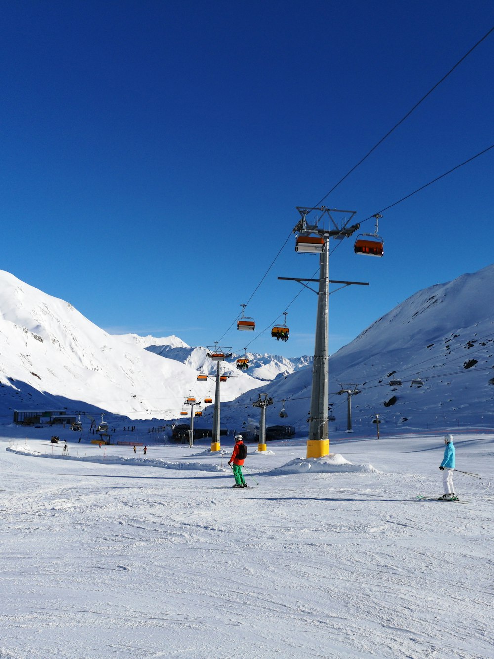 two people skiing on snowy slope under the ski lift