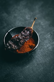 dried chili on black ceramic bowl
