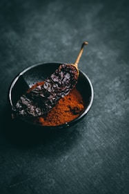 dried chili on black ceramic bowl