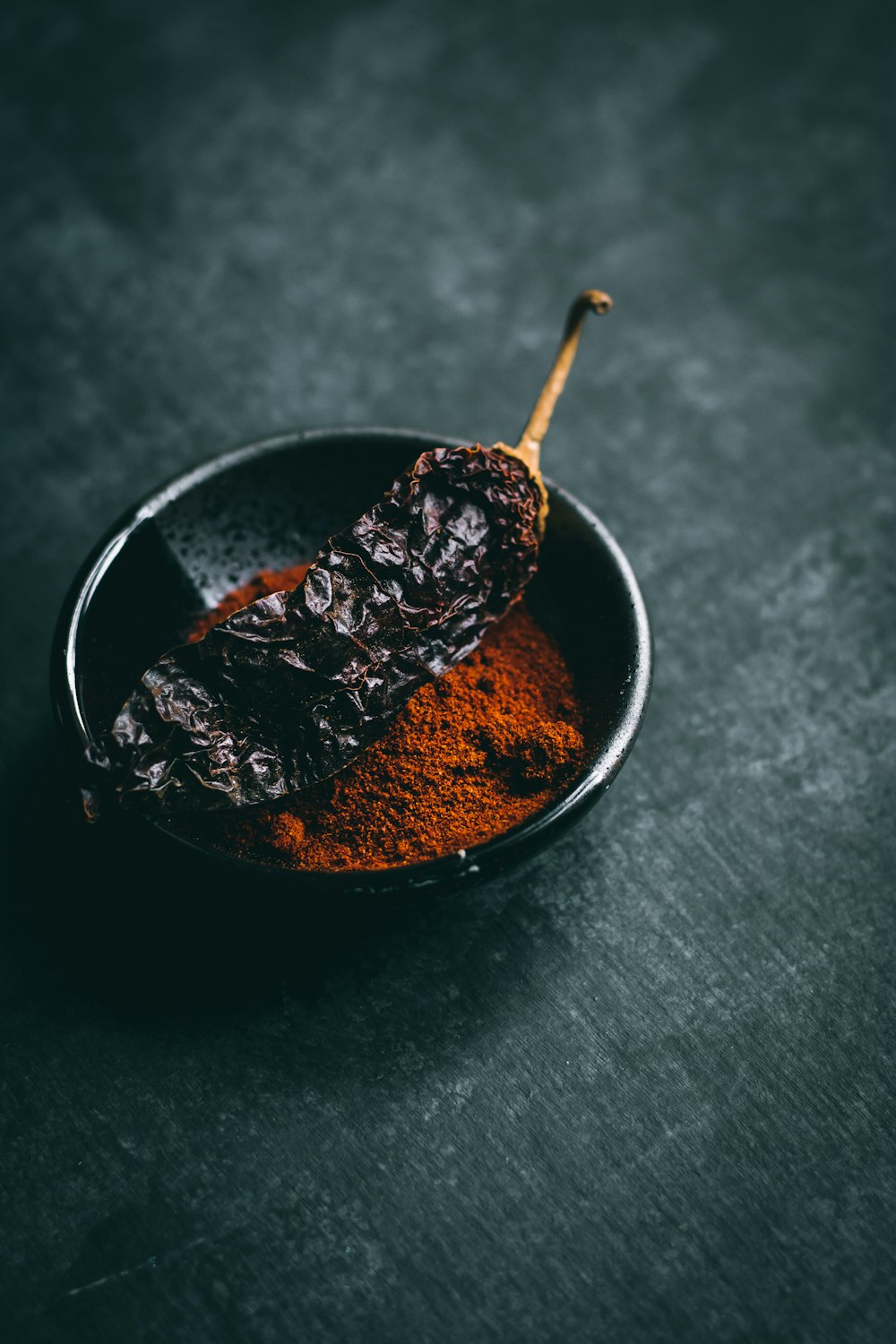 Getrocknetes Chili auf schwarzer Keramikschale