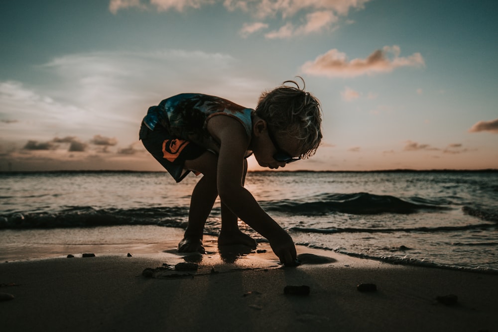 boy picking up sand