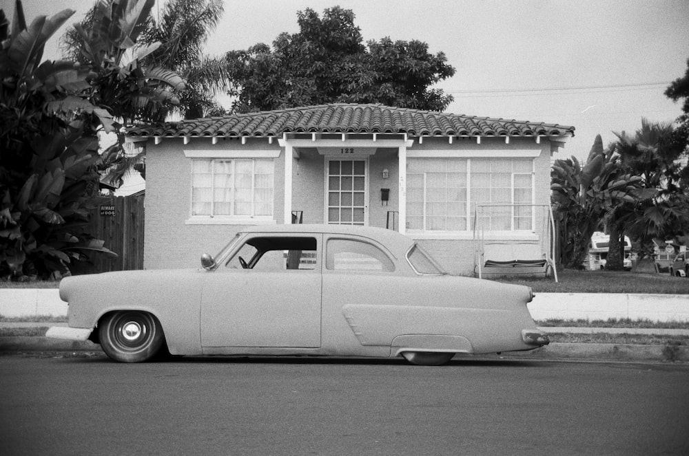 grayscale coupe parked on roadside