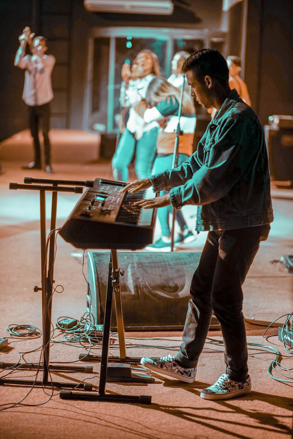 Mann in schwarzer Jacke spielt elektrisches Keyboard