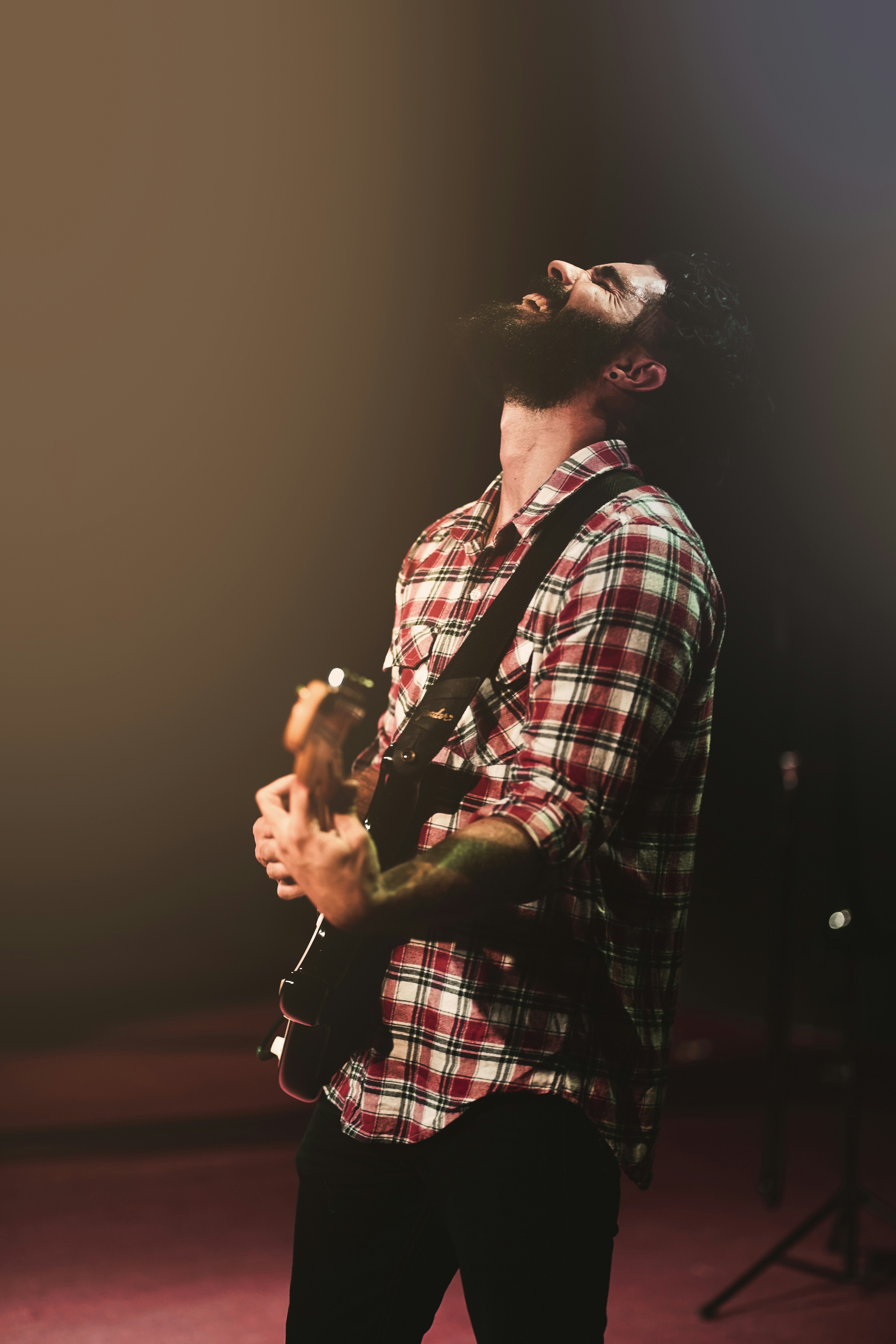 man in plaid sport shirt playing guitar