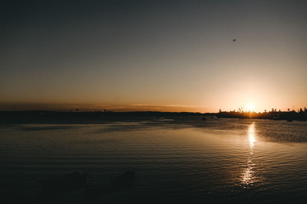 the sun is setting over a body of water