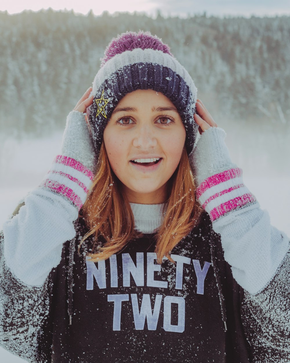 woman touching her bobble hat covered with snow