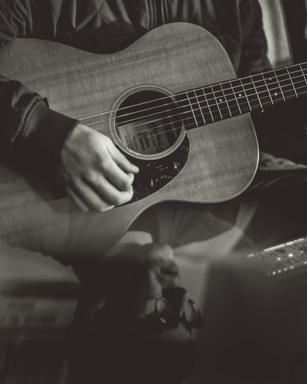 greyscale photography of person playing acoustic guitar