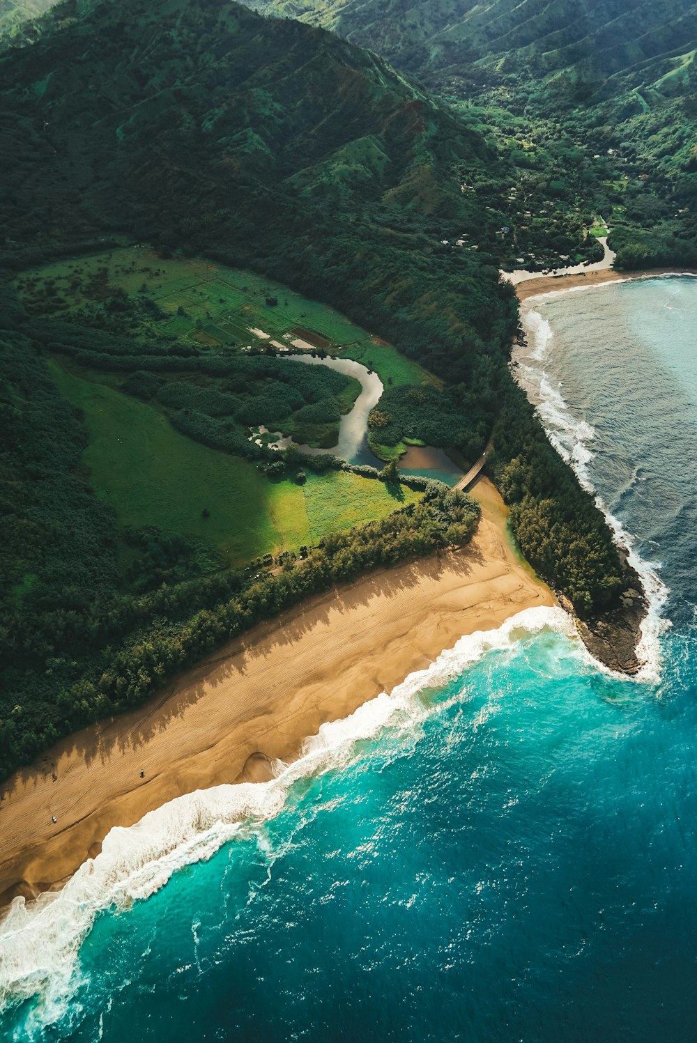 high angle photography of sea beside green mountain