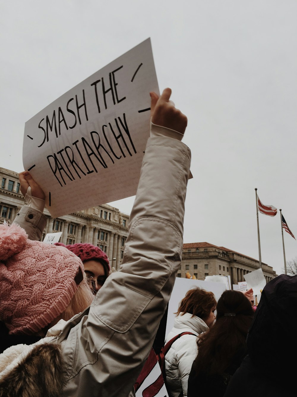 feminist holding white paper with smash the patriarchy