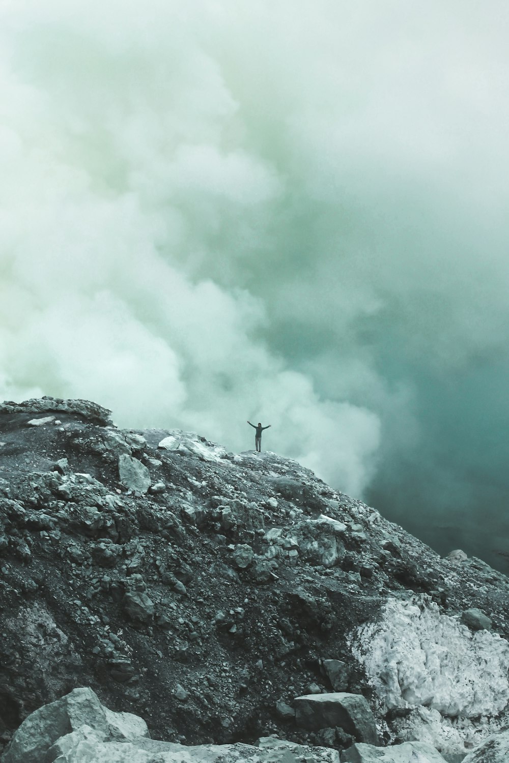 Persona de pie en el acantilado con el fondo de las nubes