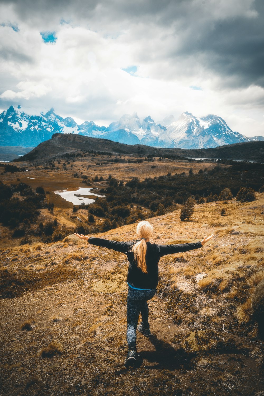 woman standing at middle of mountain