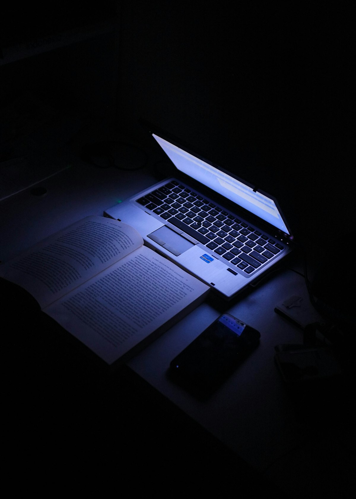 Minimal laptop setup on a dim, focused desk